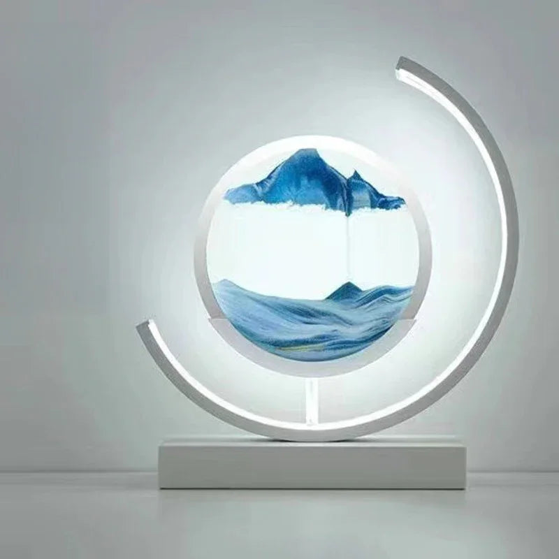 Modern LED sand art lamp with blue sandscape and circular design on a white table