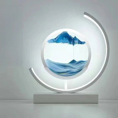 Modern LED sand art lamp with blue sandscape and circular design on a white table