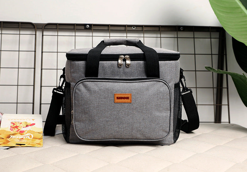 Gray cooler bag with a brand logo on a tiled floor