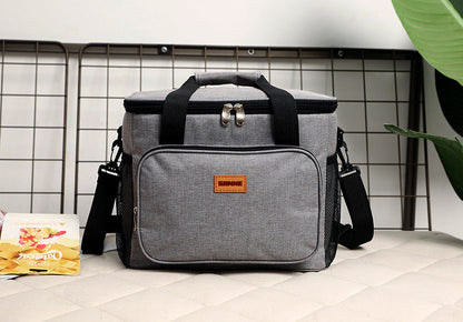 Gray cooler bag with a brand logo on a tiled floor