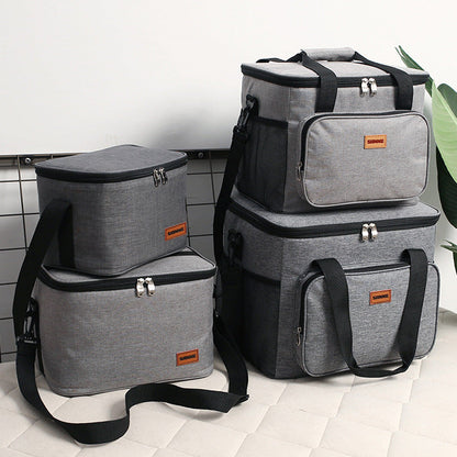 Set of gray and black insulated bags on a tiled floor.