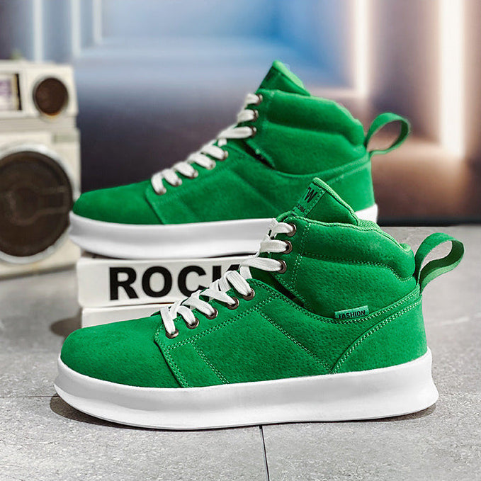 Green high-top sneakers with white laces on a gray surface, with a laptop and newspaper in the background.