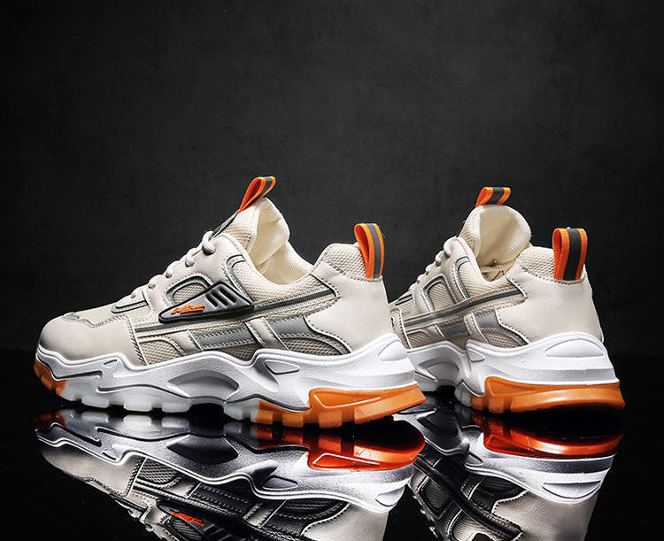 Pair of white and orange sneakers on a reflective black surface with a dark background