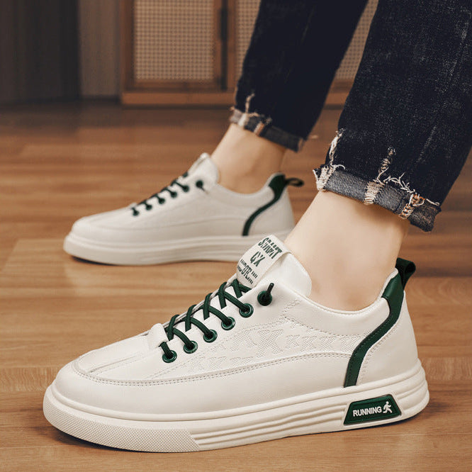 White sneakers with green accents worn by a person on a wooden floor.