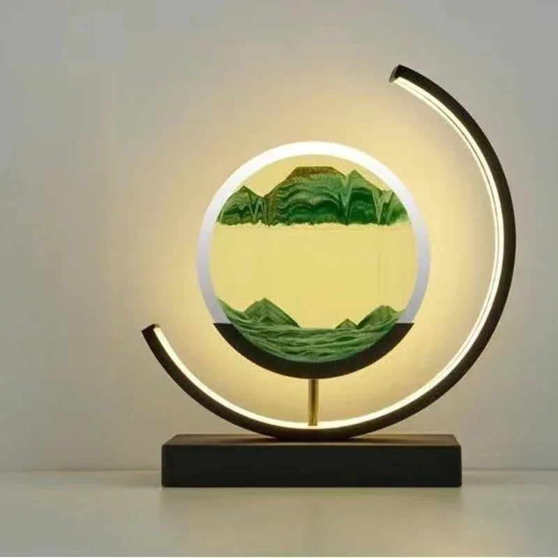 Modern round LED table lamp with sand art scene and minimalist design on white surface