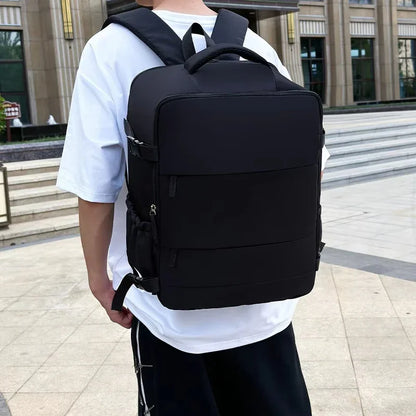 Man wearing large black backpack outdoors, modern urban setting, casual travel gear