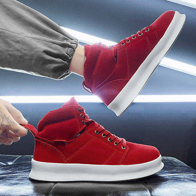 Red high-top sneakers being worn with a focus on movement and style.
