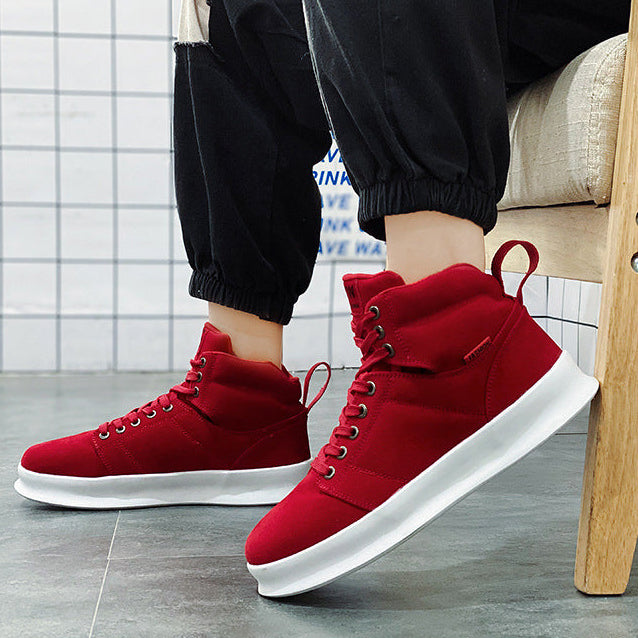 Red high-top sneakers being worn with a blurred background
