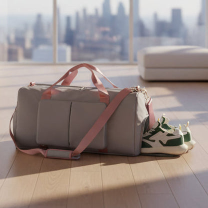 Gray duffel bag with pink straps containing green and white sneakers on a white background