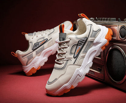 Beige sneakers with orange accents on a red surface with a vintage radio in the background