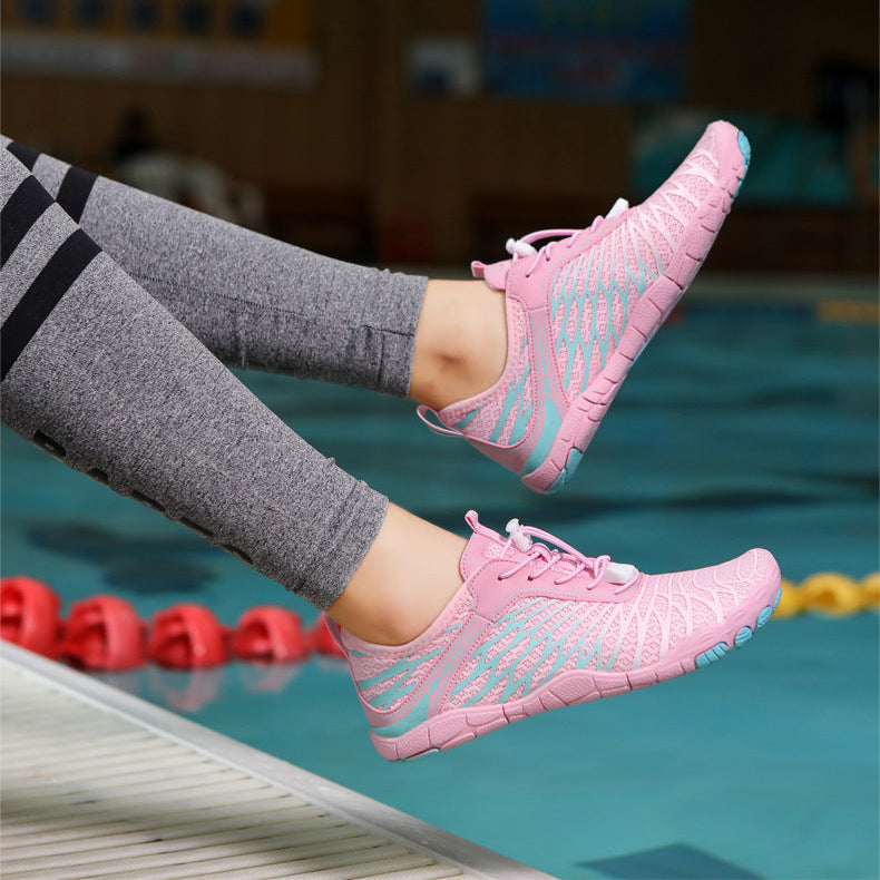 Person wearing pink sneakers with blue accents by a pool