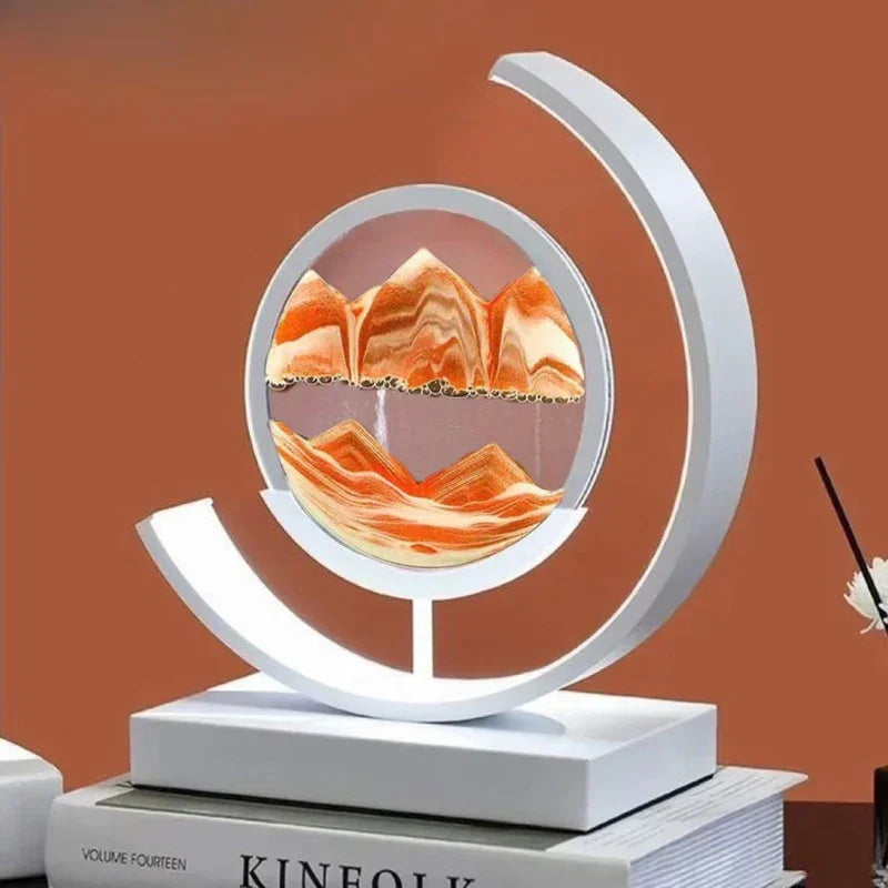 Modern round sand art sculpture with orange mountain pattern on a white base, tabletop decor