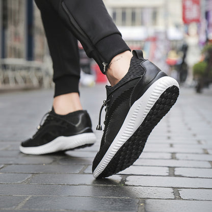 Black sneakers with white soles worn on a blurred street background