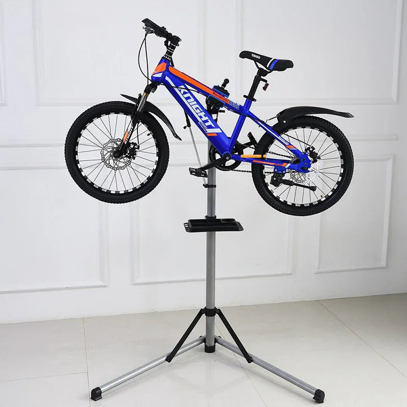Blue and orange mountain bike mounted on a repair stand in a white indoor room