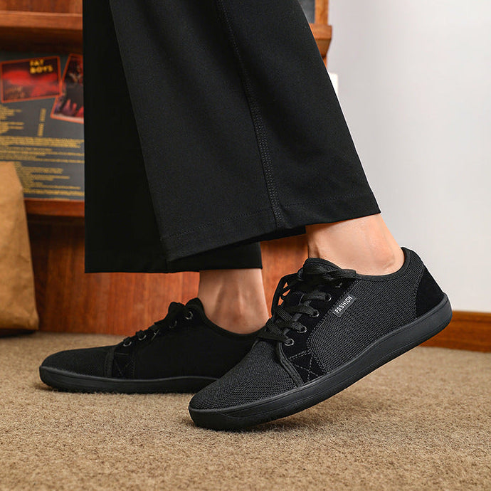 Person wearing black sneakers with a blurred indoor background