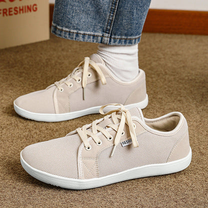 Beige sneakers worn with white socks on a carpeted floor, with a Coca-Cola box in the background.