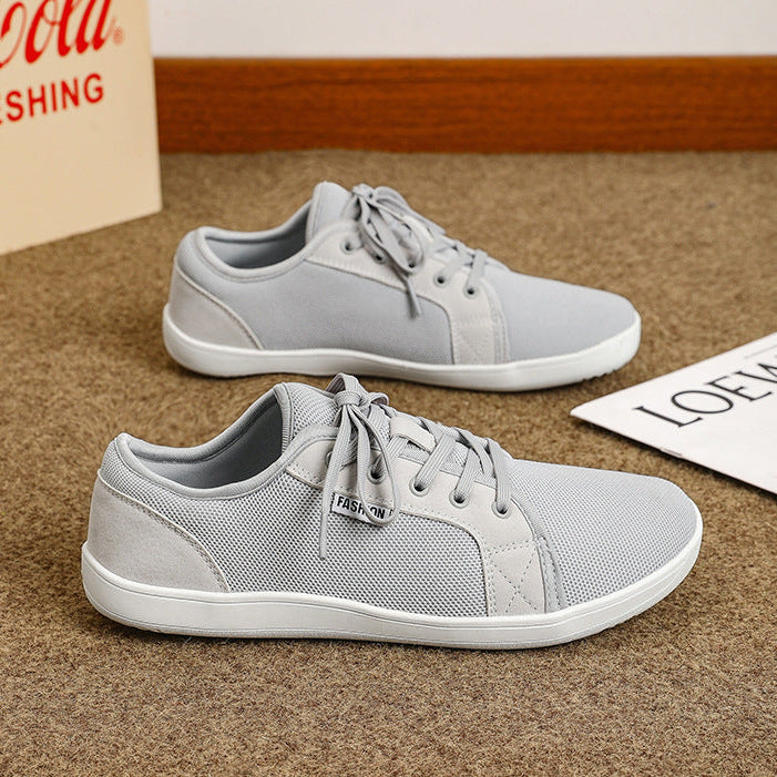 Gray sneakers on a textured surface with a Coca-Cola box in the background