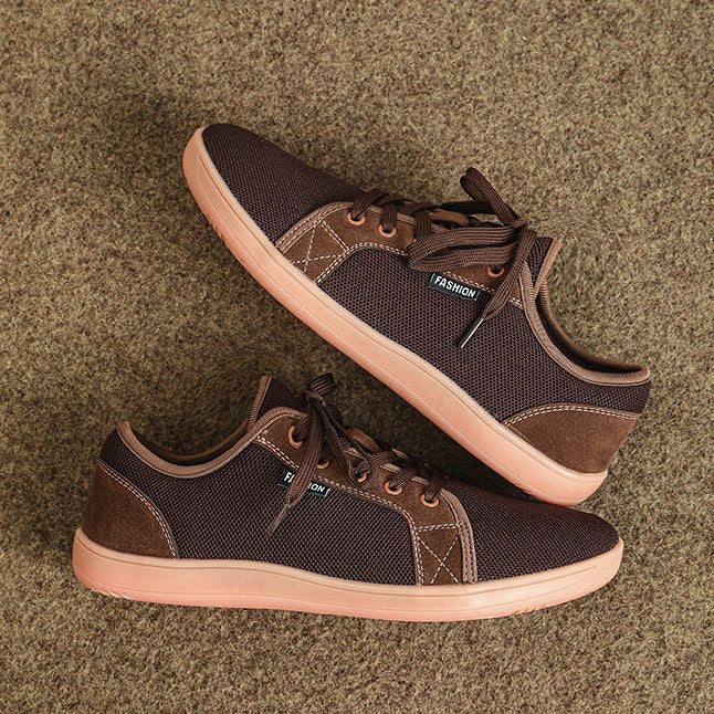 Pair of brown sneakers with tan soles on a textured brown background